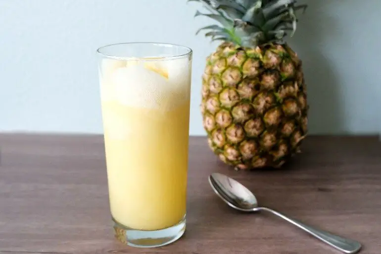 pineapple float with a spoon and pineapple in the background