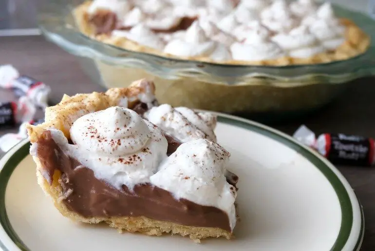 slice of pudding pie with tootsie rolls and a whole pie behind it