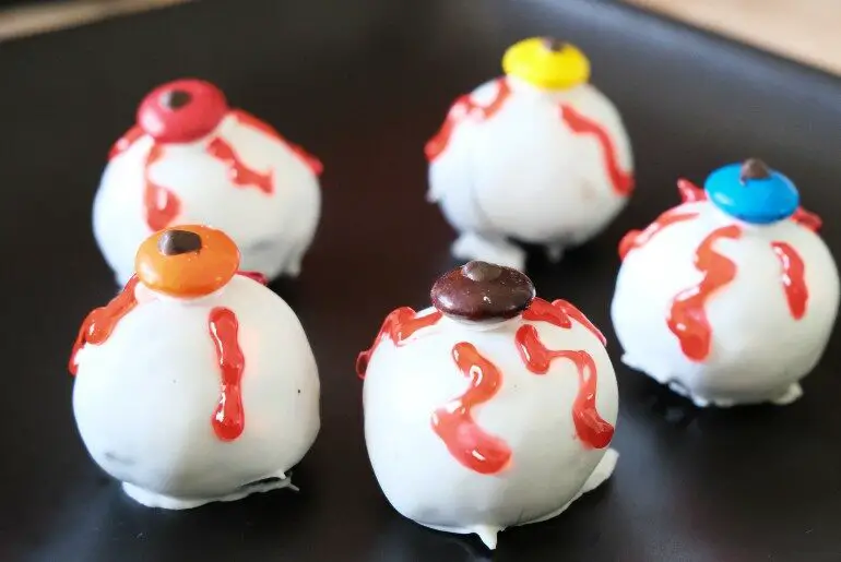 5 eyeball truffles arranged on a black plate