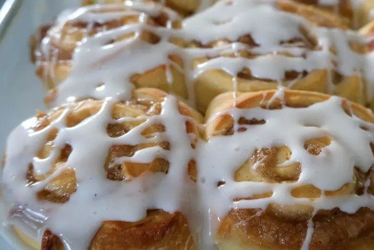 rhubarb rolls with icing in a glass pan